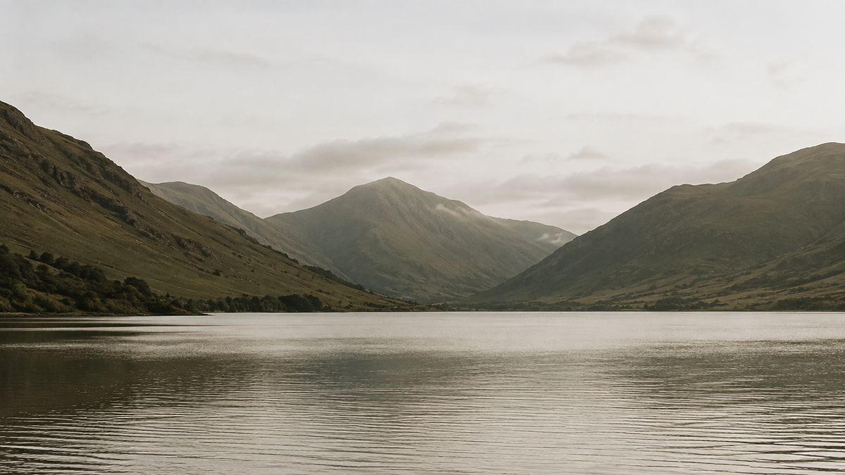 Calm lake between green mountains at dusk