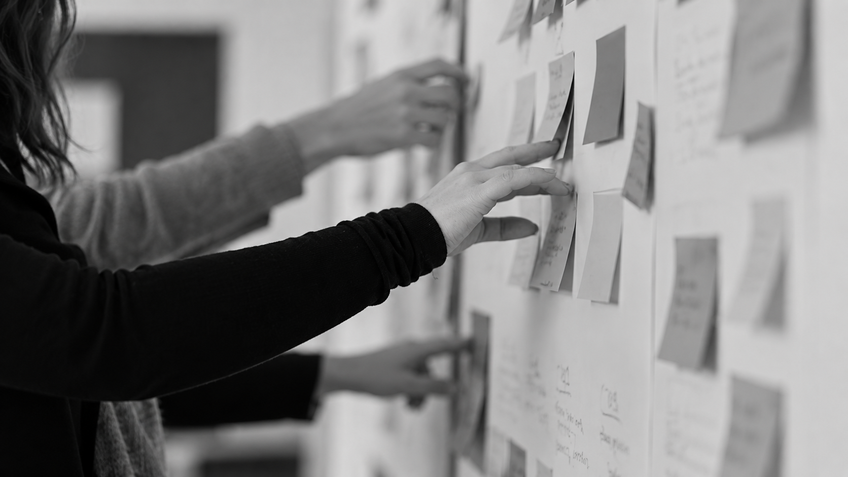 Team arranging sticky notes on a planning wall